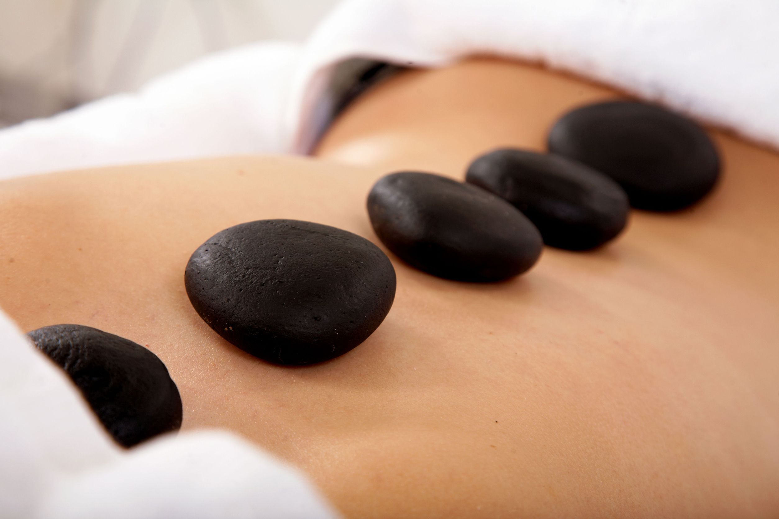 Row of hot stones placed along the spine during a massage